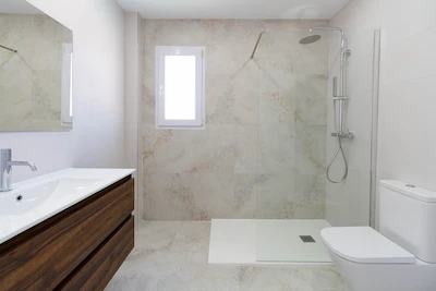 Baño reformado con ducha de obra y mampara de cristal